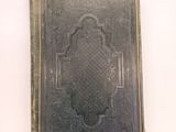 an old book sitting on top of a white table next to a white wall