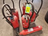three fire extinguisors are sitting on the floor in a warehouse