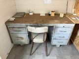 a desk with a chair and a computer on it in a room