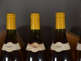 four bottles of wine are lined up in a wooden box