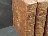 several old books are stacked on top of each other on a table