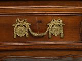 a close up of a wooden dresser with a brass handle