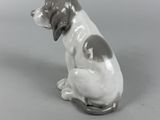 a figurine of a dog that is sitting on the ground