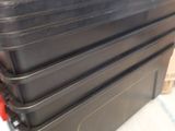 a stack of black plastic containers sitting on top of each other