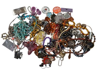 a pile of assorted necklaces and bracelets on a white surface