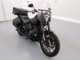 une moto noire garée dans une pièce aux murs blancs