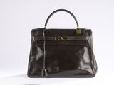 a brown leather handbag sitting on top of a white surface
