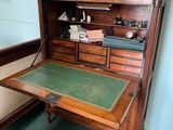 a wooden desk with a green top in a room