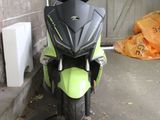 a green and black motorcycle parked next to a building