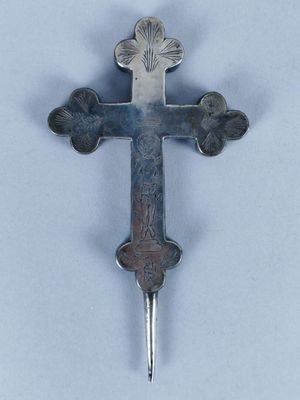 une croix argentée sur un fond blanc, dans laquelle est enfoncé un couteau