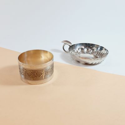 silver plated cup and saucer on a beige and white background