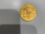 gros plan d'une pièce d'or sur une surface blanche