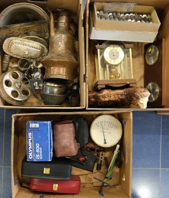 une boîte remplie d'objets divers, posée sur un sol carrelé