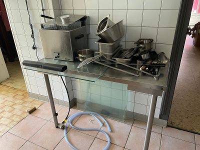 une table sur laquelle sont posés tout un tas de casseroles et de poêles