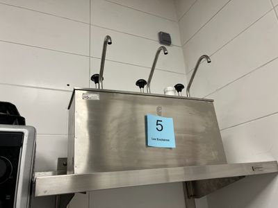 a stainless steel sink with a blue sign on top of it