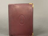 a brown leather wallet sitting on top of a gray surface
