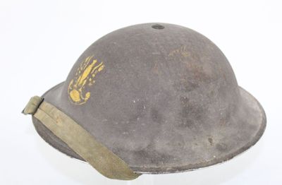 an old helmet with a gold eagle on it on a white surface