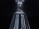 une image représentant une bouteille en verre transparent munie d'un bouchon, sur fond noir