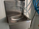 a stainless steel sink in a bathroom with a blue hose