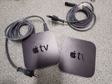 two apple tvs sitting next to each other on the floor