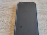 un téléphone portable noir posé sur une table à côté d'un ordinateur portable