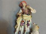 a figurine of a woman and a cat on a shelf