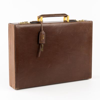 porte-documents en cuir marron sur fond blanc, avec des poignées découpées