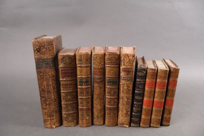 Plusieurs vieux livres sont empilés les uns sur les autres sur une surface grise