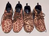 trois paires de chaussures à imprimé léopard sont alignées sur une surface blanche