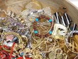 a wooden bowl filled with assorted jewelry and other items