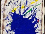 des éclaboussures de peinture bleue et jaune sur une feuille de papier blanche