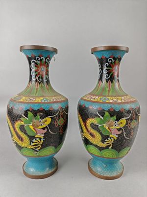 two vases with dragon designs on them sitting on a table