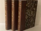 trois livres posés sur une table blanche