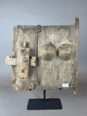 une vieille porte en bois munie d'un loquet métallique fixé sur un support