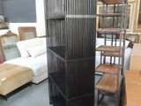 a tall black bookcase in the middle of a room filled with furniture