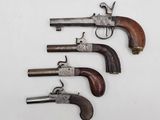 four old guns are lined up on a white surface
