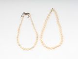 a pair of pearl necklaces on a white background
