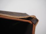 someone is holding a brown bag with a zipper on it