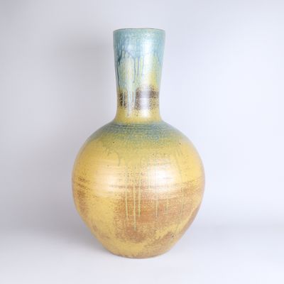 a yellow and blue vase sitting on a white surface