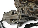 a statue of a woman sitting on a rock with a guitar