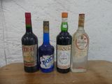 Plusieurs bouteilles d'alcool sont alignées sur une table en bois