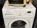 a microwave sitting on top of a washing machine