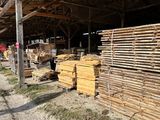 a large pile of wood sitting in the middle of a dirt field