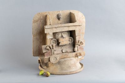 une petite statue représentant un homme avec des bananes posée sur une table