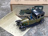 une petite voiture miniature posée sur une table, à côté d'une boîte
