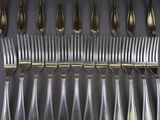 a lot of forks and spoons that are on the table