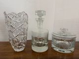trois vases en verre posés sur une table l'un à côté de l'autre