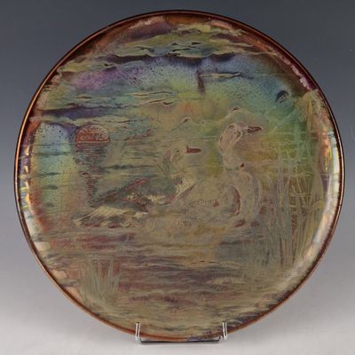 a plate with a painting on it sitting on a stand
