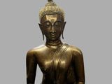 statue of a seated buddha holding a bowl in his hands