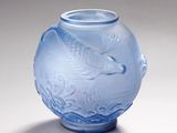 un vase bleu orné d'un poisson, posé sur une table